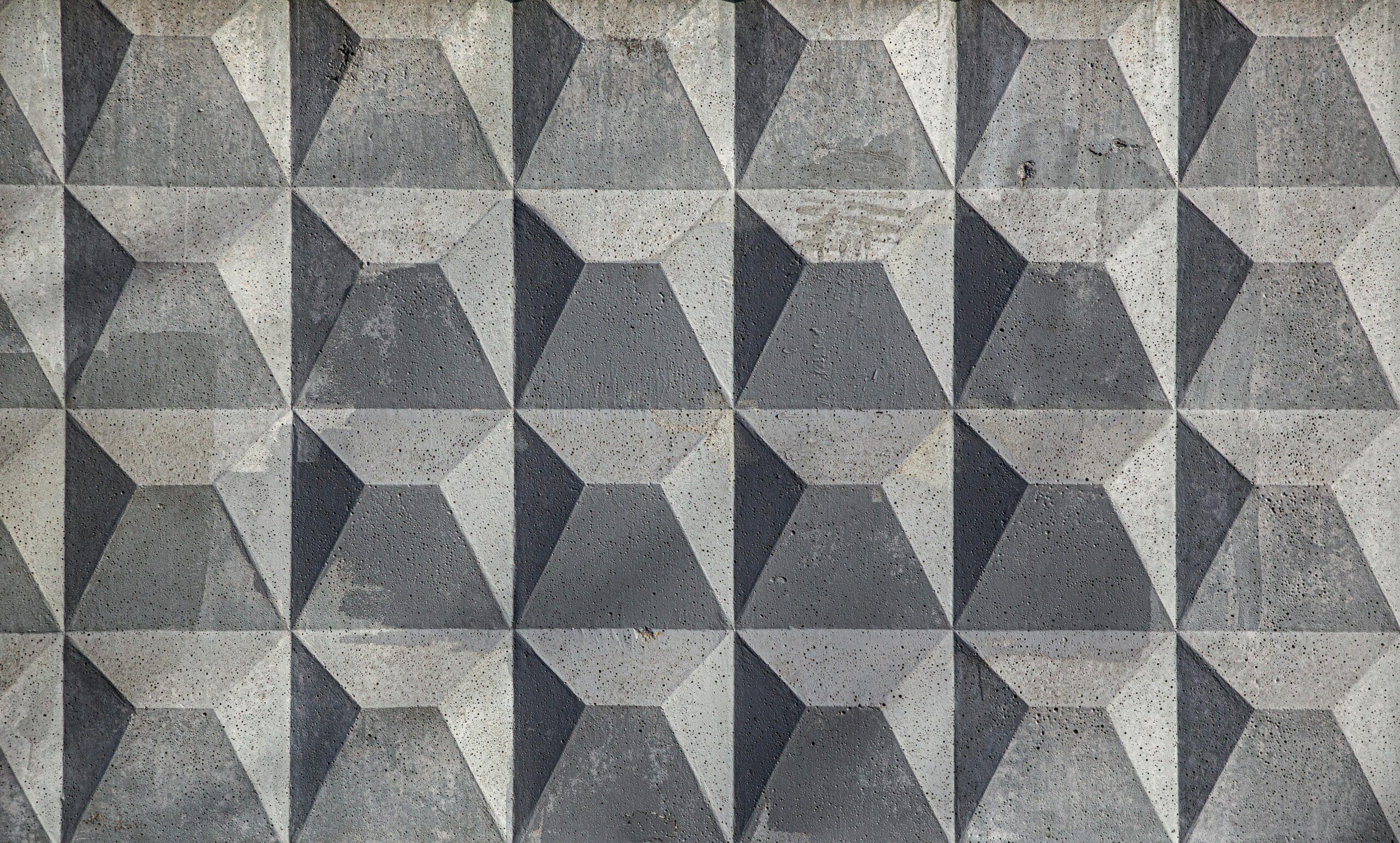 Close-up of a textured geometric concrete wall with a pattern.